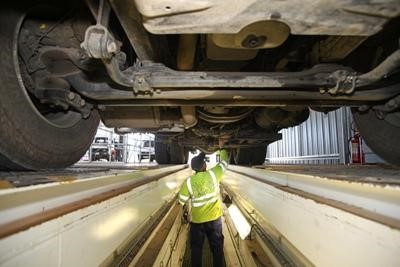 D&G Assist technician inspecting underneath a lifted HGV in the workshop